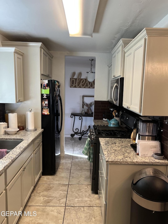 kitchen with light stone countertops, sink, light tile patterned flooring, and stainless steel appliances