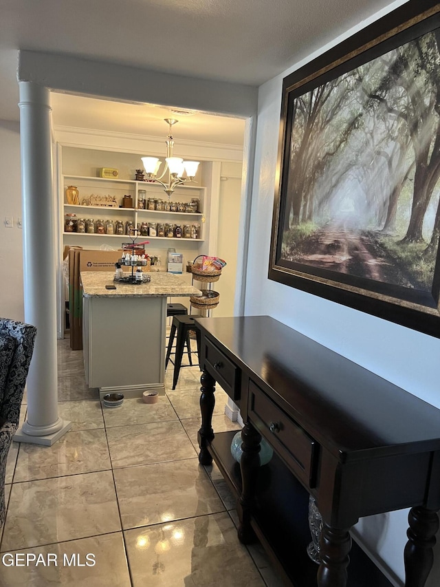 dining room with built in features, a textured ceiling, decorative columns, and an inviting chandelier