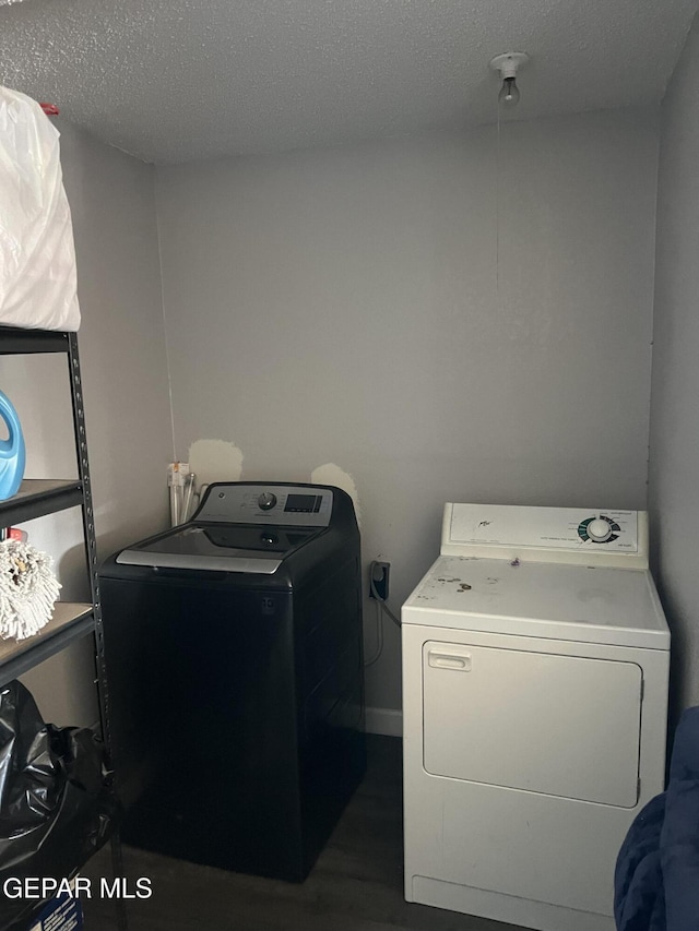 washroom with a textured ceiling and washing machine and clothes dryer