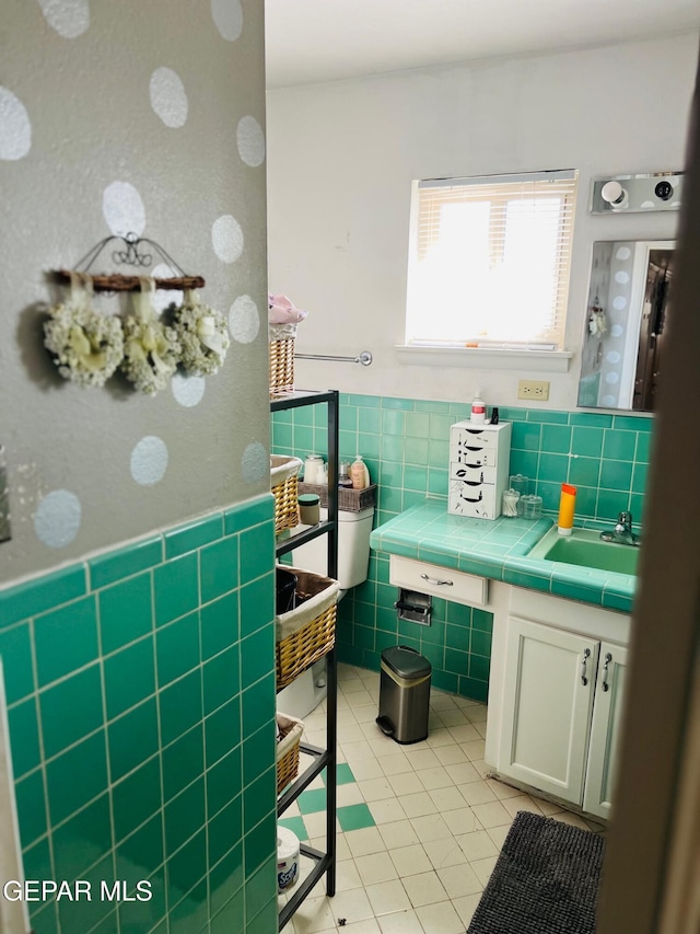 bathroom featuring tile patterned floors, vanity, and tile walls