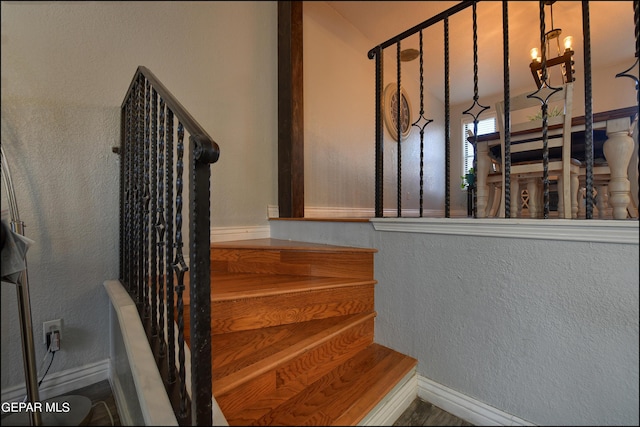 stairway featuring an inviting chandelier