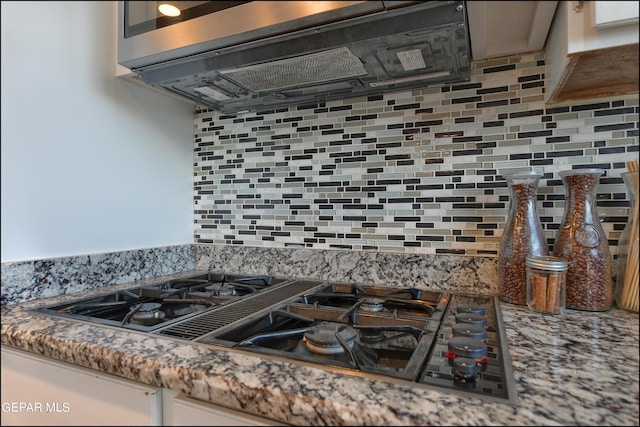 kitchen featuring black gas stovetop and backsplash