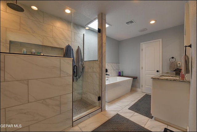 bathroom with tile patterned flooring, vanity, and shower with separate bathtub