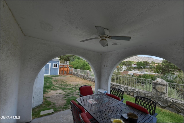 view of patio featuring a mountain view, ceiling fan, and an outdoor structure