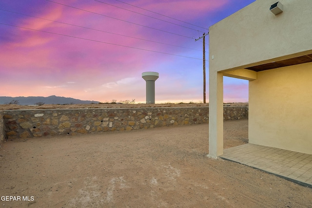 yard at dusk featuring a mountain view