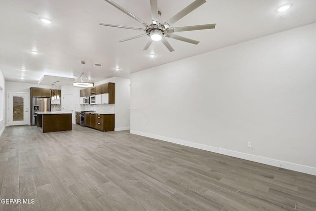 unfurnished living room with hardwood / wood-style floors and ceiling fan