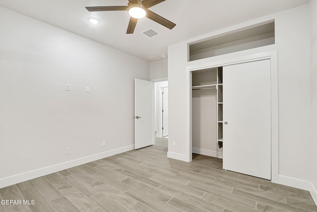 unfurnished bedroom featuring ceiling fan, a closet, and light wood-type flooring