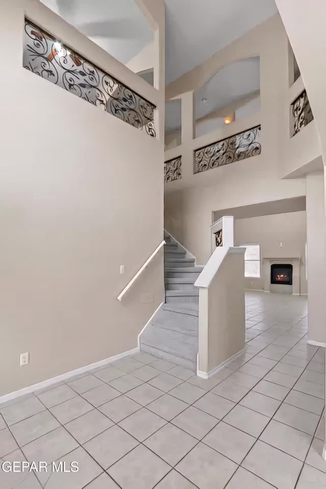 stairs featuring tile patterned flooring and a towering ceiling