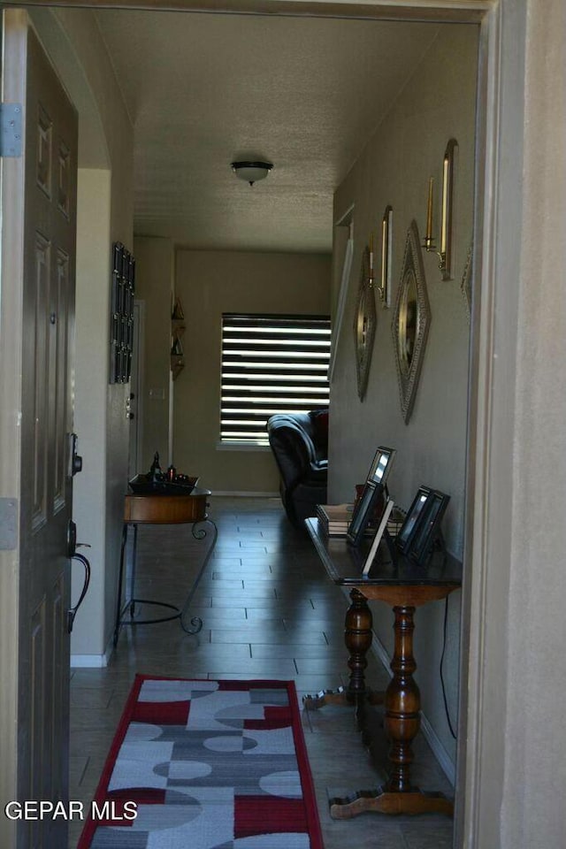 corridor featuring hardwood / wood-style floors and a textured ceiling