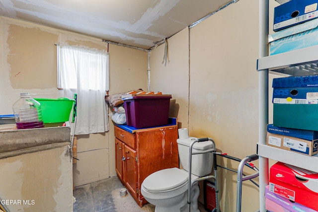 bathroom featuring concrete flooring and toilet