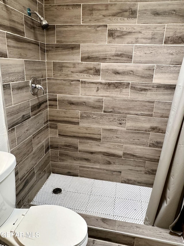 bathroom featuring curtained shower and toilet