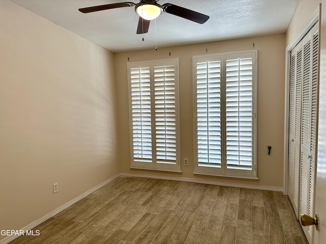 unfurnished bedroom with ceiling fan, a closet, and light hardwood / wood-style floors