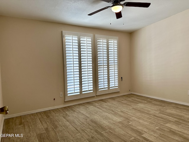 empty room featuring ceiling fan, light hardwood / wood-style flooring, and a healthy amount of sunlight