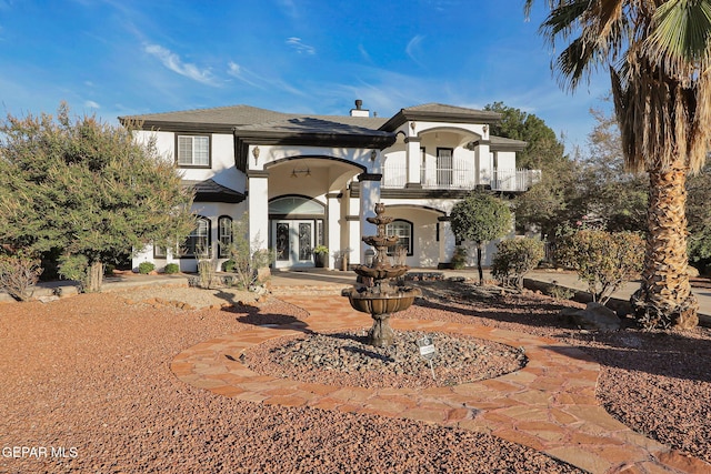 view of front facade with a balcony and french doors