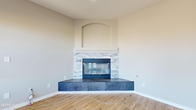 interior space featuring a tile fireplace and wood-type flooring