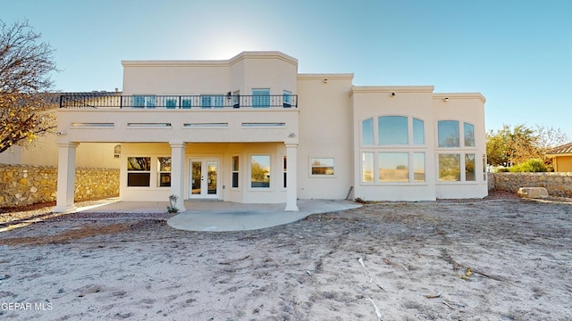 back of property with a patio area, french doors, and a balcony