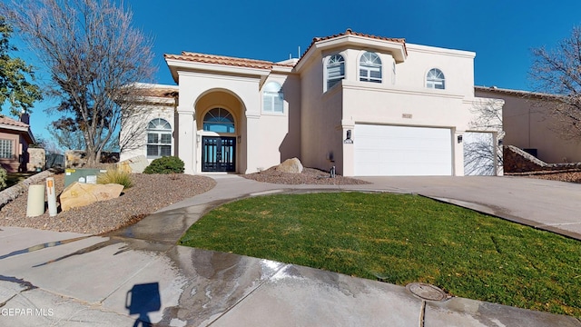 mediterranean / spanish-style house featuring a front yard and a garage