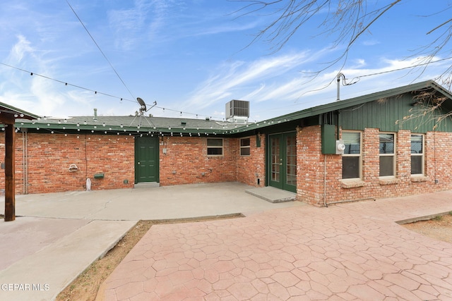 rear view of house with french doors, cooling unit, and a patio