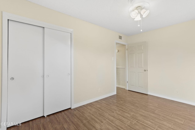 unfurnished bedroom with light hardwood / wood-style flooring and a closet