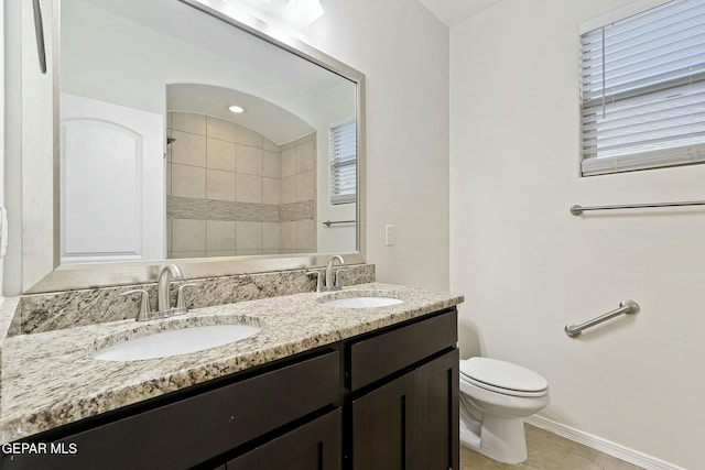 bathroom with tile patterned floors, vanity, toilet, and tiled shower