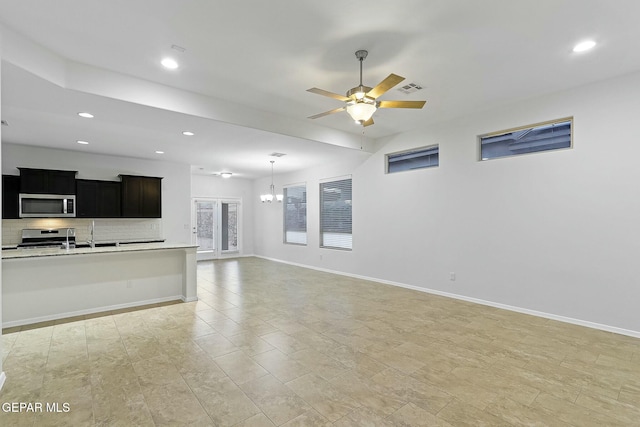 living room with ceiling fan with notable chandelier and sink