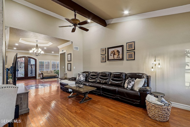 living room featuring french doors, ceiling fan with notable chandelier, crown molding, and wood-type flooring