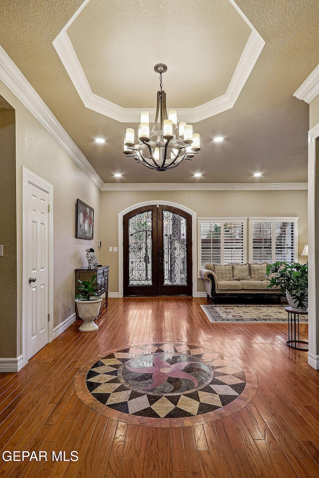 foyer with a chandelier, french doors, a textured ceiling, and hardwood / wood-style floors