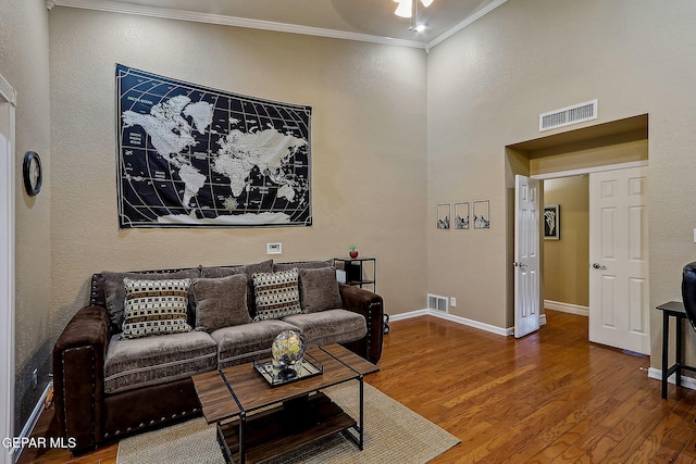 living room with wood-type flooring and ornamental molding