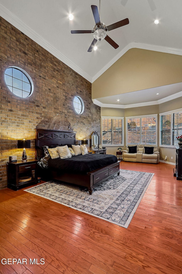 bedroom featuring brick wall, lofted ceiling, light wood-type flooring, ceiling fan, and crown molding