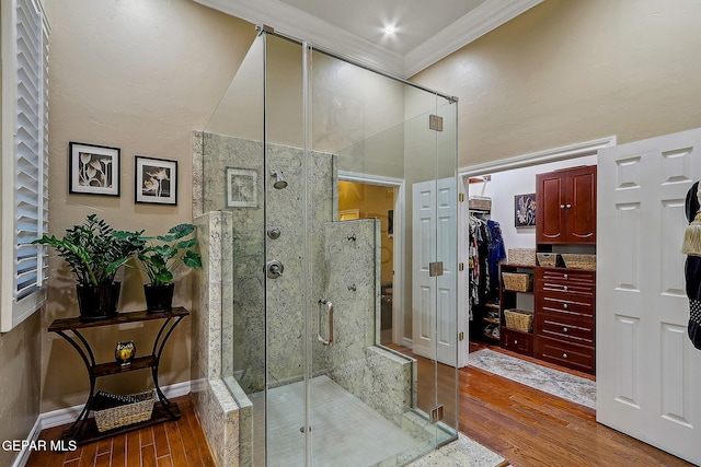 bathroom with wood-type flooring, an enclosed shower, and crown molding