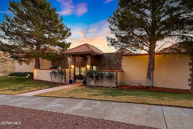 mediterranean / spanish-style home with a lawn