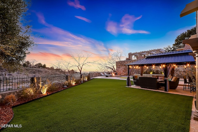 yard at dusk with a patio area, outdoor lounge area, and a pergola