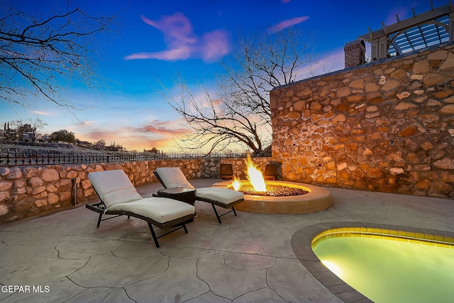 patio terrace at dusk featuring a fire pit