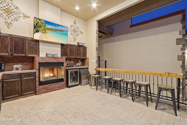 view of patio / terrace featuring wine cooler, a brick fireplace, and exterior bar