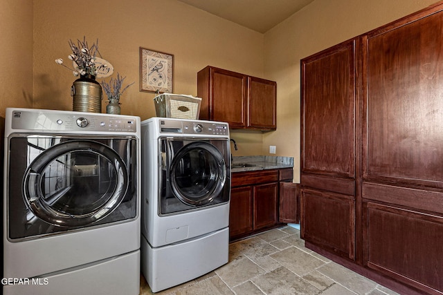 washroom with cabinets, sink, and washing machine and clothes dryer