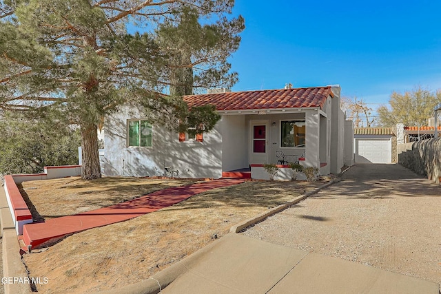 view of front of property featuring covered porch, a garage, and an outdoor structure