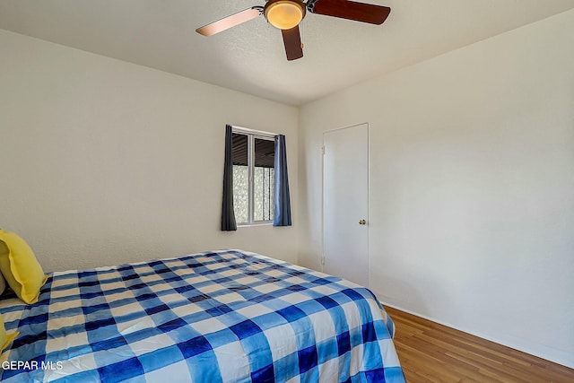 bedroom with ceiling fan and wood-type flooring