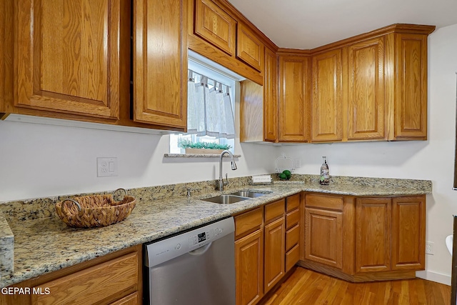 kitchen featuring dishwasher, light hardwood / wood-style floors, light stone counters, and sink