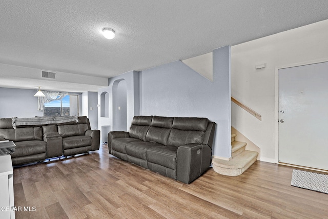 living room featuring a textured ceiling and light hardwood / wood-style flooring