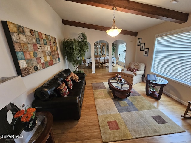 living room featuring beam ceiling and light wood-type flooring