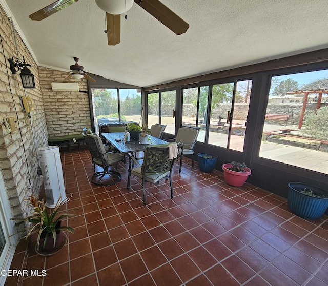 sunroom / solarium with a wall mounted air conditioner, plenty of natural light, ceiling fan, and vaulted ceiling