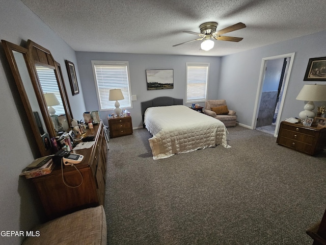 bedroom featuring ceiling fan, dark carpet, a textured ceiling, and connected bathroom