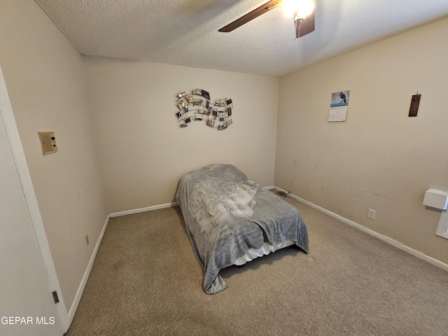 bedroom with carpet flooring, ceiling fan, and a textured ceiling