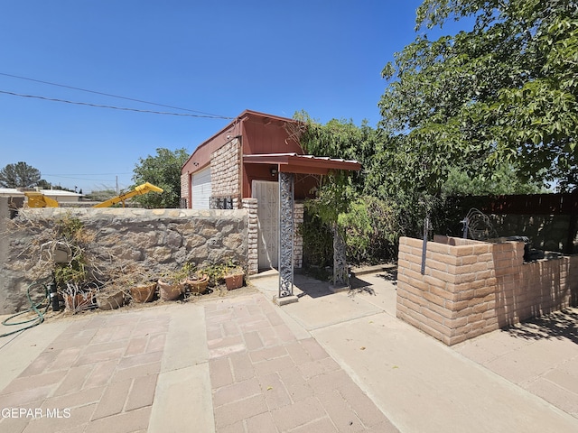 view of patio / terrace with a garage and an outdoor structure