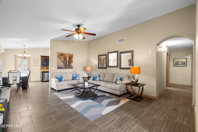 living room featuring ceiling fan with notable chandelier