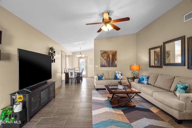 living room featuring ceiling fan with notable chandelier and vaulted ceiling