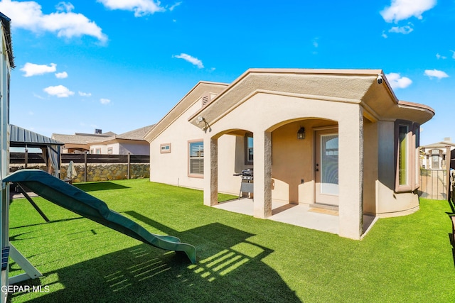 rear view of property featuring a patio and a yard