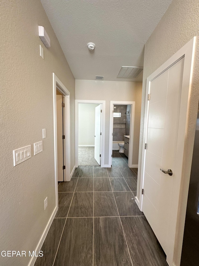 hallway featuring a textured ceiling