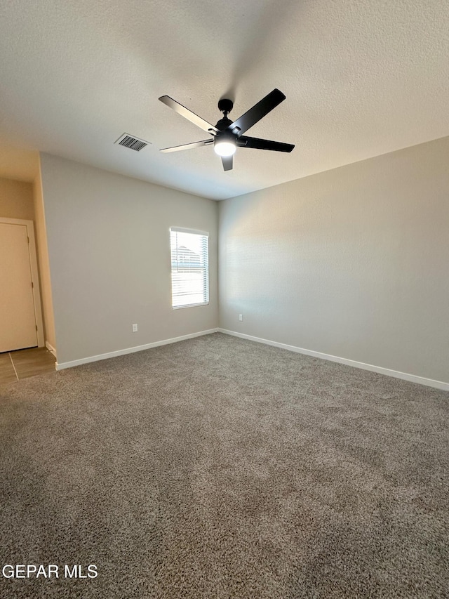 carpeted spare room with ceiling fan and a textured ceiling