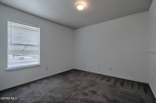 carpeted spare room featuring a textured ceiling